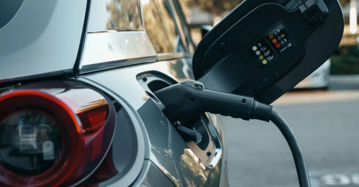 Gros plan sur un véhicule électrique en cours de chargement, mettant en avant la technologie moderne des énergies propres.