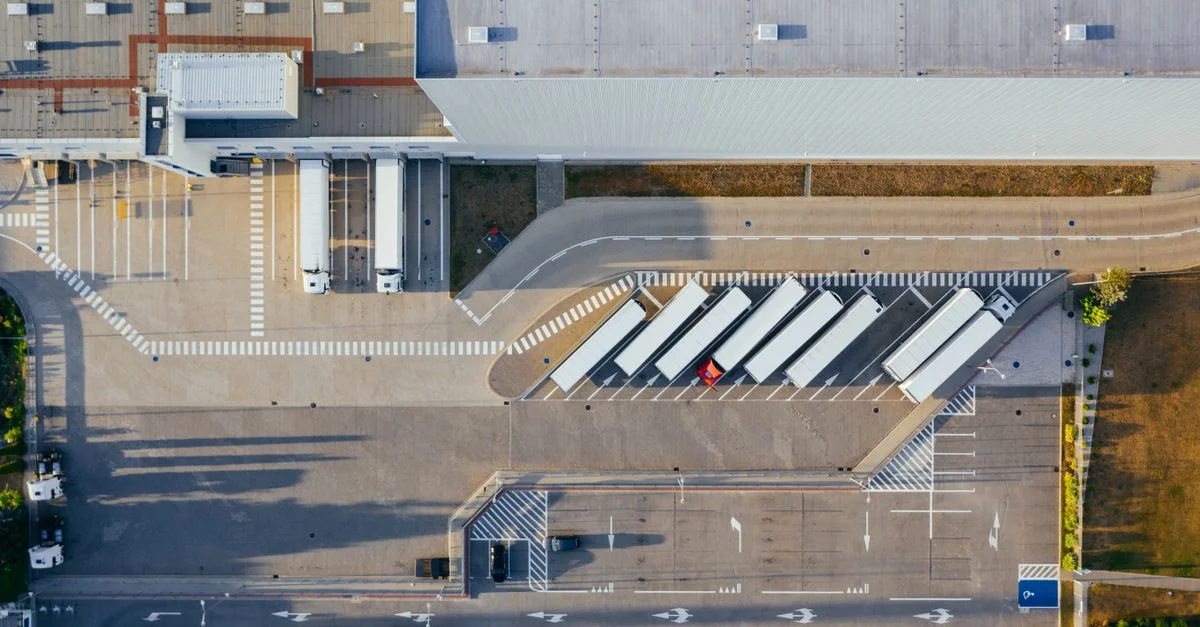 Prise de vue par drone d'un centre logistique avec camions et parking à Poznań, Pologne.