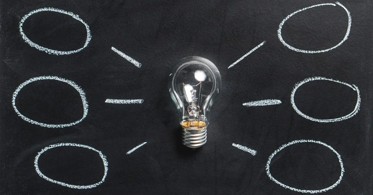 Une ampoule sur un tableau noir symbolise la créativité, l'innovation et les idées.