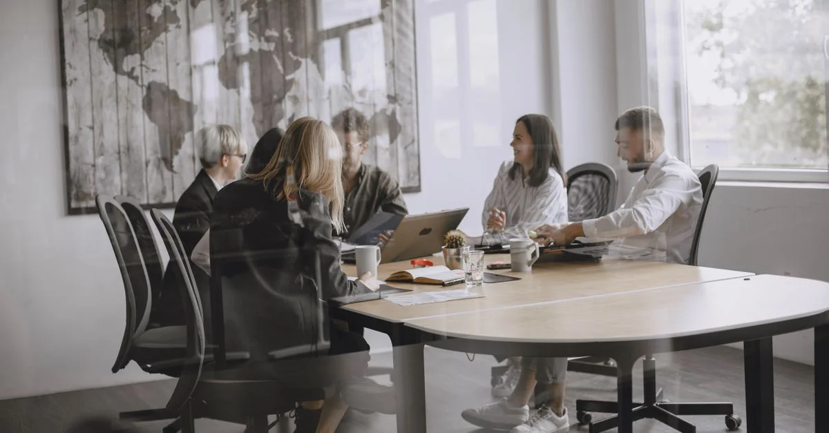 Un groupe diversifié de collègues en réunion dans un bureau moderne.
